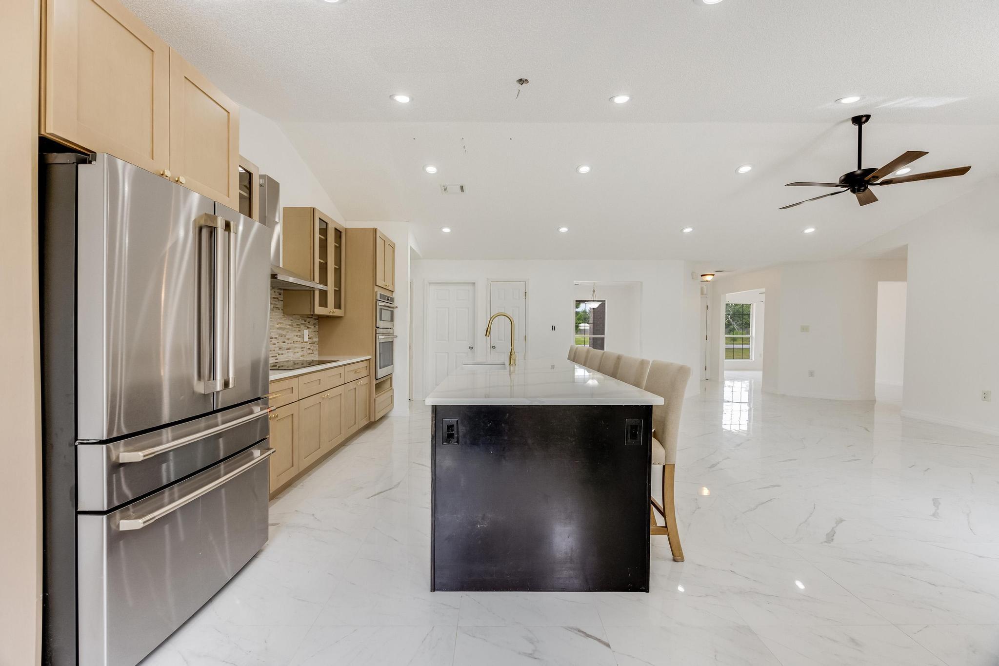 4140 Big Buck Trail Crestview, FL 32539 - Photo 9 of 40 a kitchen with stainless steel appliances kitchen island a refrigerator sink and cabinets