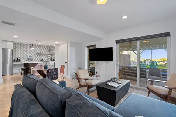 a living room with patio furniture and a potted plant