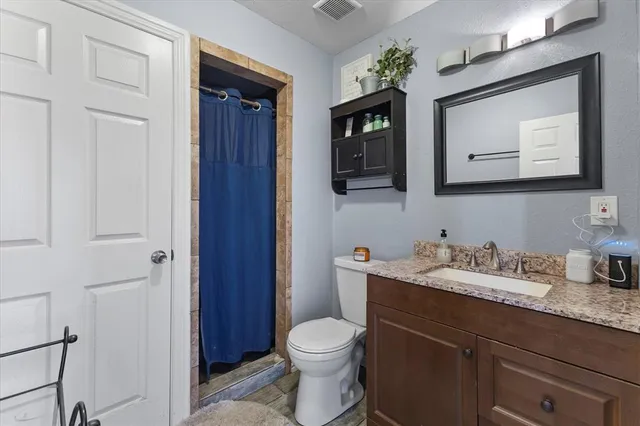 a bathroom with a toilet a sink a vanity and mirror