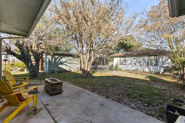 a view of a backyard with table and chairs and a fire pit