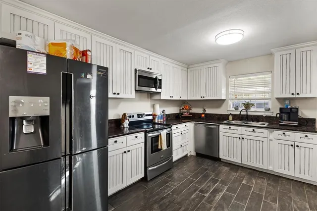 a kitchen with stainless steel appliances granite countertop a refrigerator stove microwave and sink