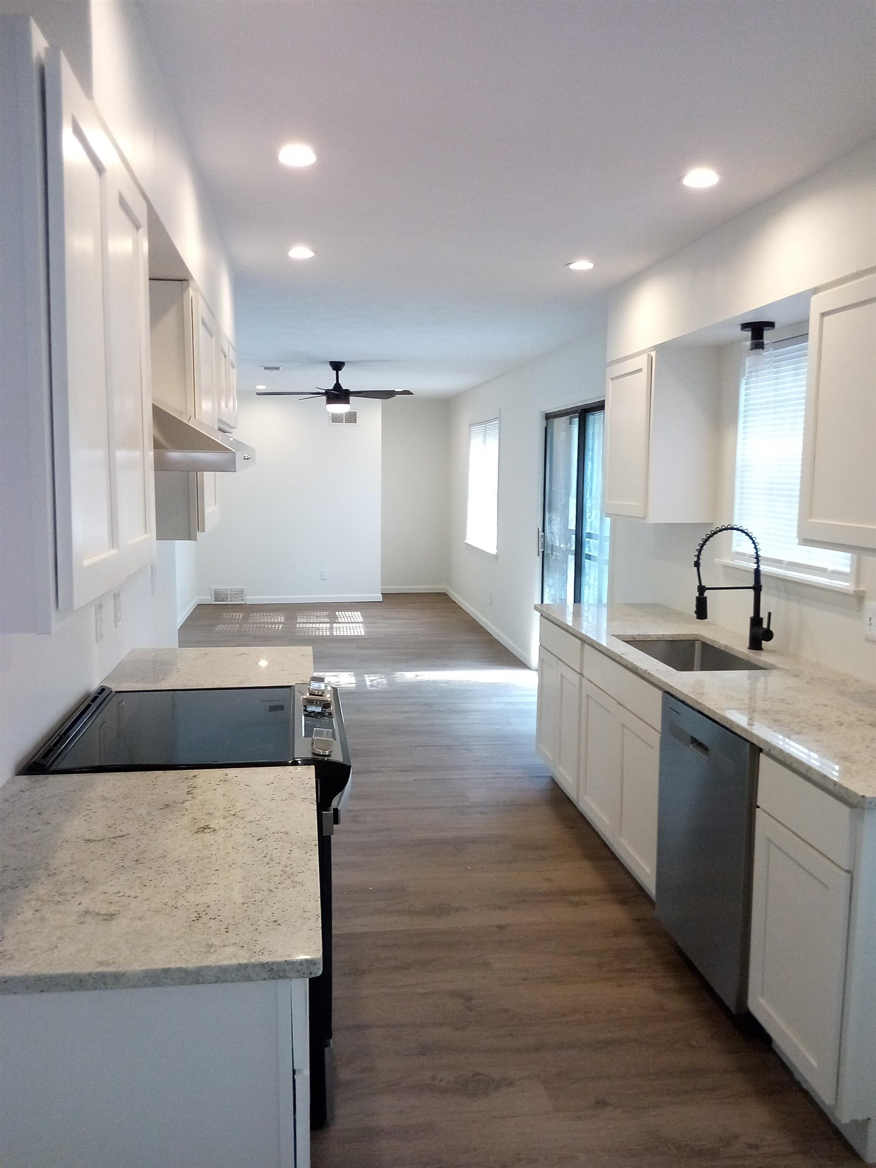 4425 Hodge Road Memphis, TN 38109 - Photo 15 of 37 a large kitchen with kitchen island a sink dishwasher a stove and a refrigerator with wooden floor