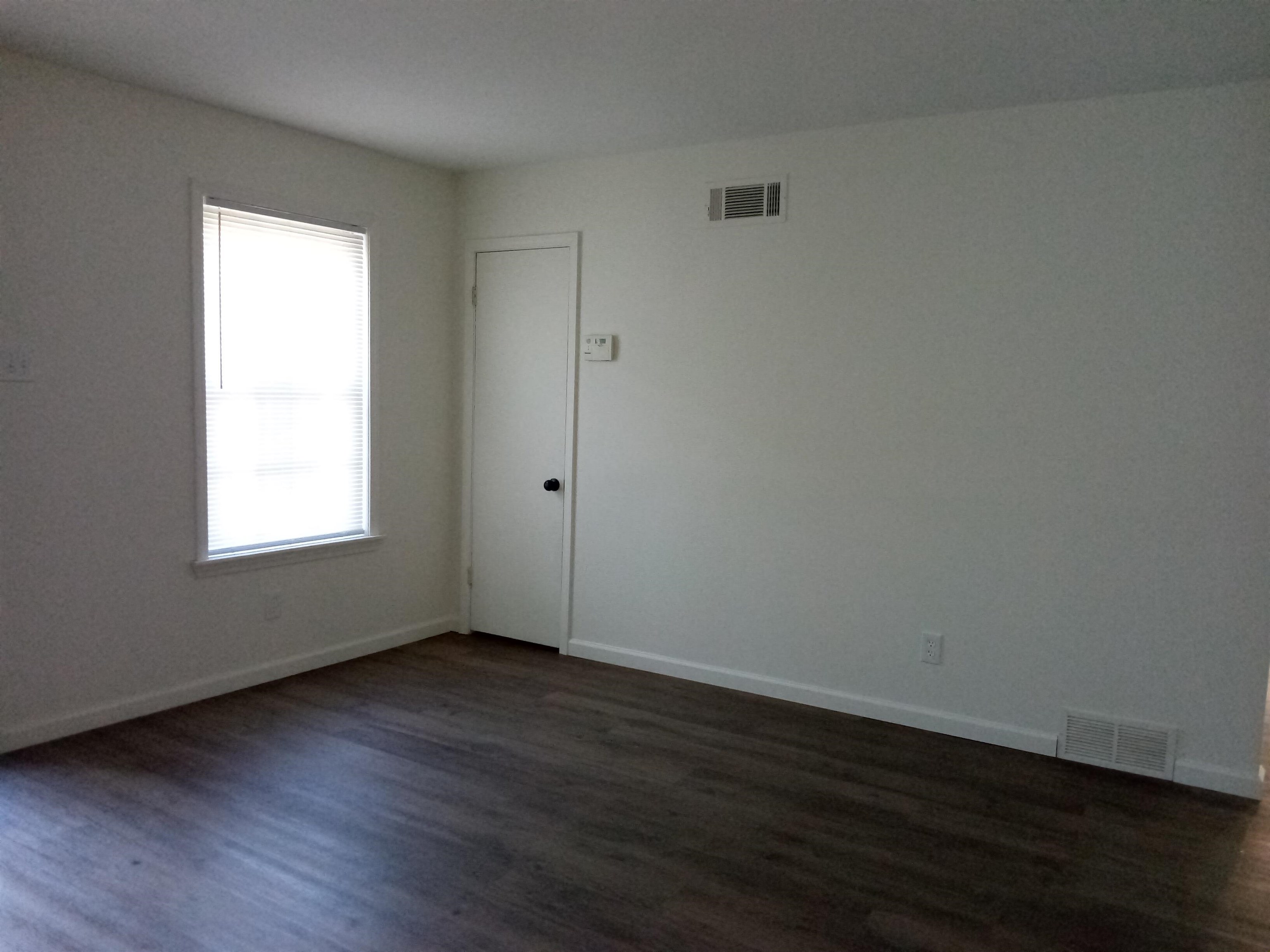 4425 Hodge Road Memphis, TN 38109 - Photo 3 of 37 a view of an empty room with wooden floor and a window