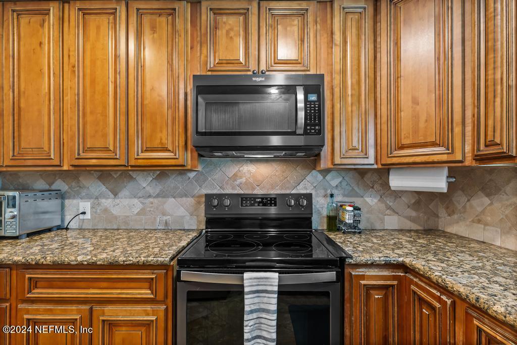 3645 Marianna Road Jacksonville, FL 32217 - Photo 11 of 44 a kitchen with granite countertop wood cabinets stainless steel appliances and a window