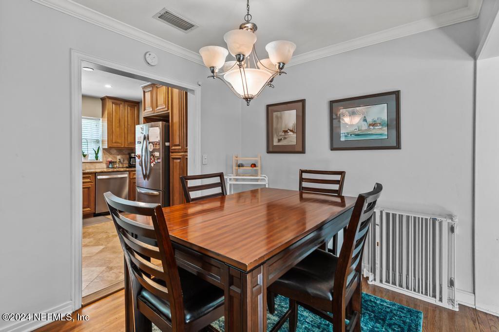 3645 Marianna Road Jacksonville, FL 32217 - Photo 13 of 44 a dining room with wooden floor a chandelier a wooden table and chairs
