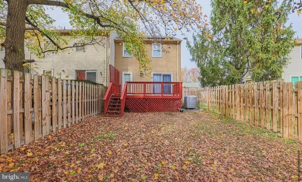 a view of a house with wooden fence and a large tree