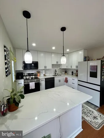 a kitchen with stainless steel appliances kitchen island granite countertop a sink and a stove