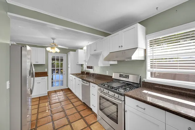 a large kitchen with stainless steel appliances granite countertop a stove and a sink
