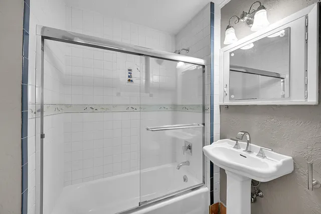a bathroom with a sink mirror and shower