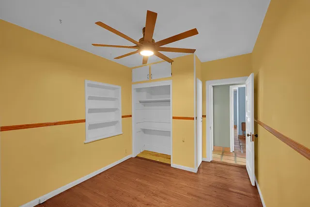 a view of empty room with wooden floor