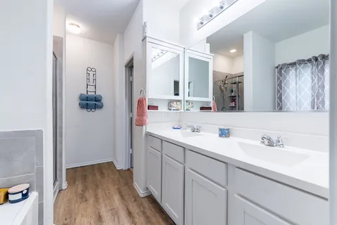 a bedroom with a bed a couch and a chandelier