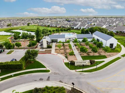 an aerial view of residential houses with outdoor space and parking