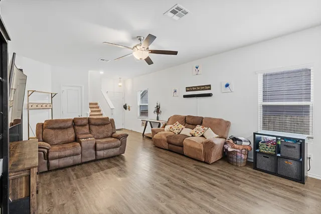 a living room with furniture and wooden floor