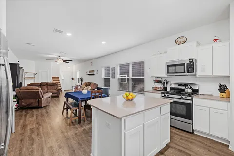 a kitchen with a refrigerator a stove a sink dishwasher a oven with a dining table and chairs