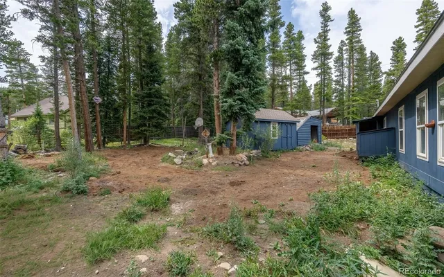 a view of house with backyard and trees