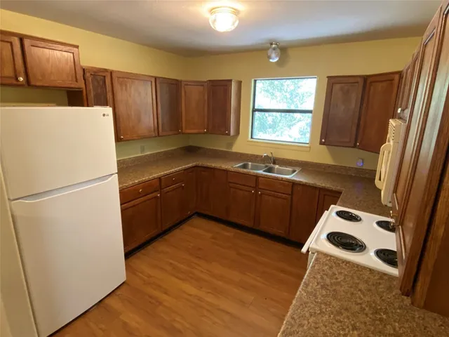 a view of a kitchen with wooden floor and electronic appliances