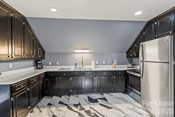 a kitchen with stainless steel appliances granite countertop a sink stove and refrigerator