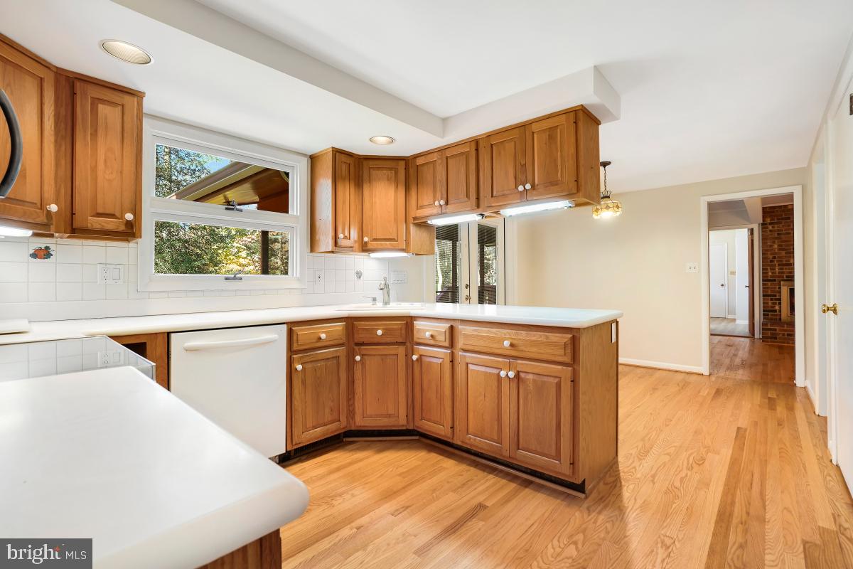 2606 Deerdell Lane Reston, VA 20191 - Photo 10 of 49 a kitchen with stainless steel appliances granite countertop a sink dishwasher stove and wooden cabinets with wooden floor