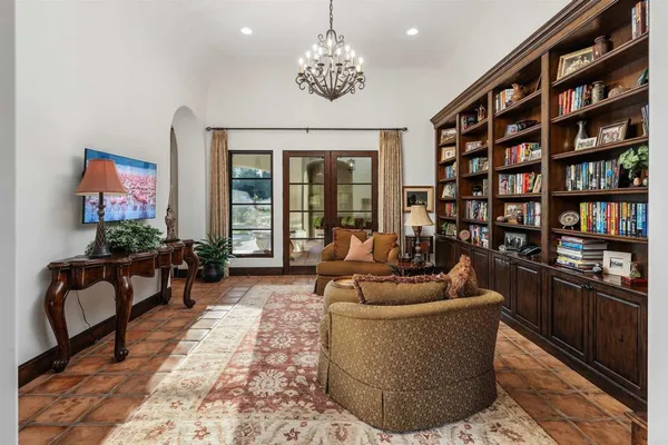 a living room with furniture a bookshelf and a flat screen tv