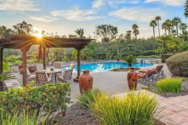 a view of a patio with furniture and a garden