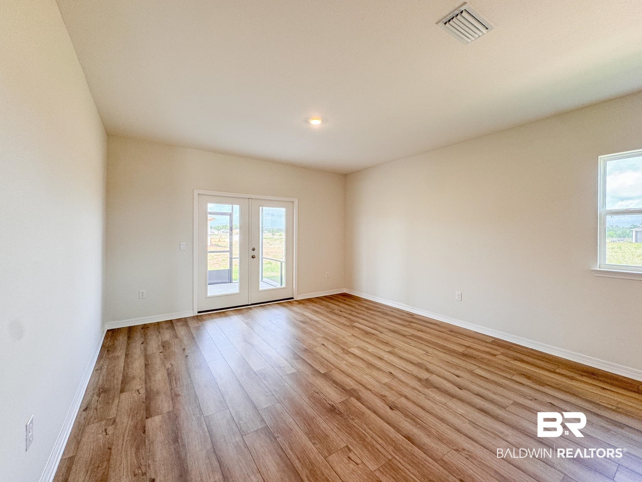 18151 Kent Circle Foley, AL 36535 - Photo 12 of 25 Spacious interior featuring wood-finish flooring, neutral-toned walls, and a vaulted ceiling