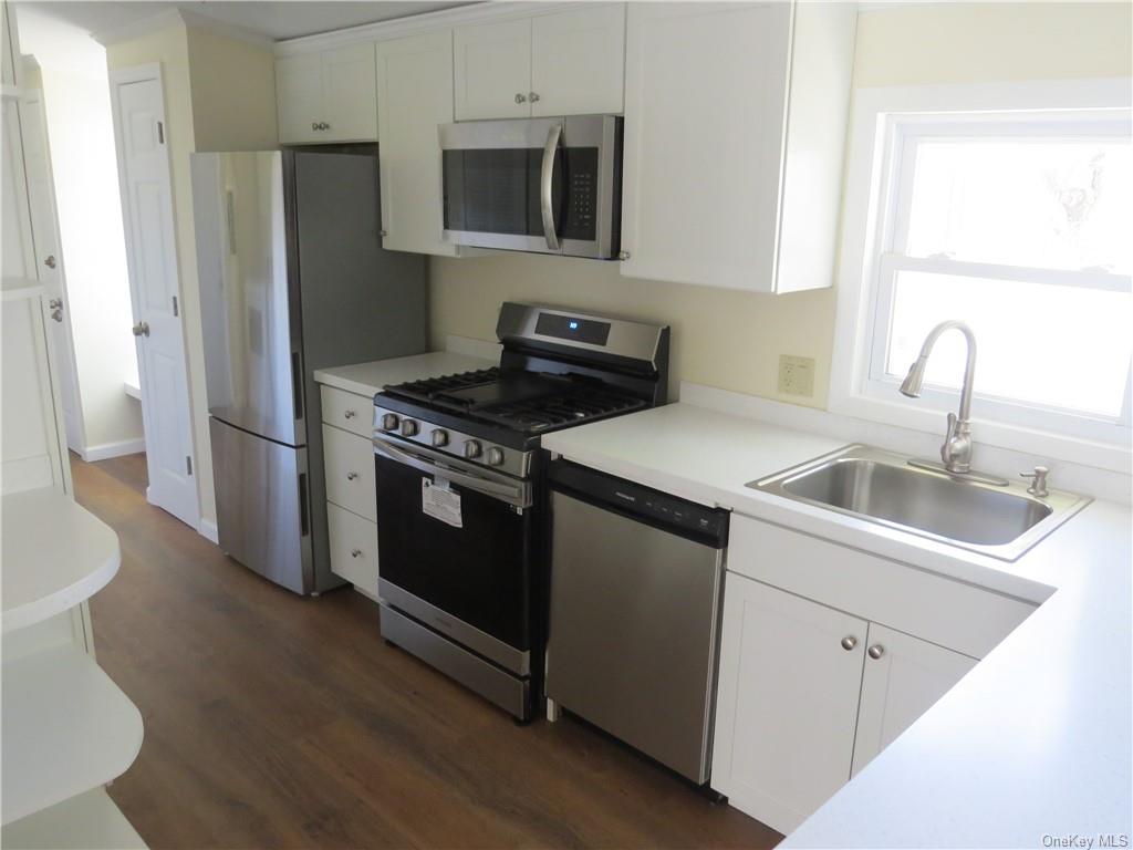 723 Beekman Road Hopewell Junction, NY 12533 - Photo 12 of 33 Kitchen featuring sink, white cabinets, stainless steel appliances, and dark hardwood / wood-style floors
