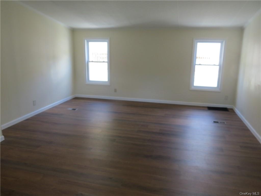 723 Beekman Road Hopewell Junction, NY 12533 - Photo 14 of 33 Empty room featuring plenty of natural light and dark hardwood / wood-style floors