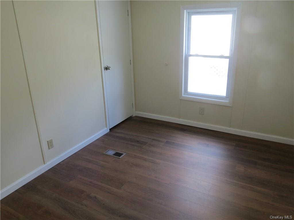 723 Beekman Road Hopewell Junction, NY 12533 - Photo 23 of 33 Empty room with a healthy amount of sunlight and dark hardwood / wood-style flooring