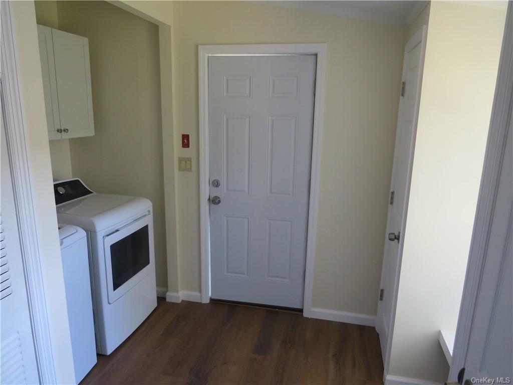 723 Beekman Road Hopewell Junction, NY 12533 - Photo 7 of 33 Laundry area with cabinets, ornamental molding, dark wood-type flooring, and washing machine and dryer