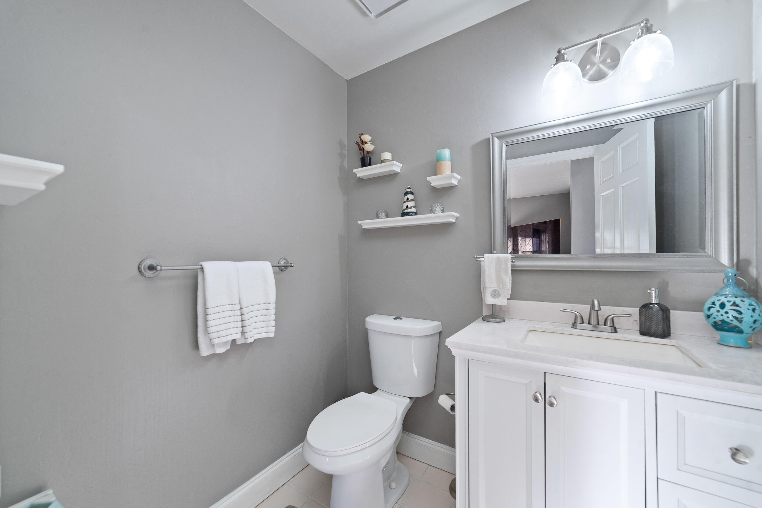 1045 Raintree Lane Wellington, FL 33414 - Photo 13 of 43 a bathroom with a toilet sink and mirror