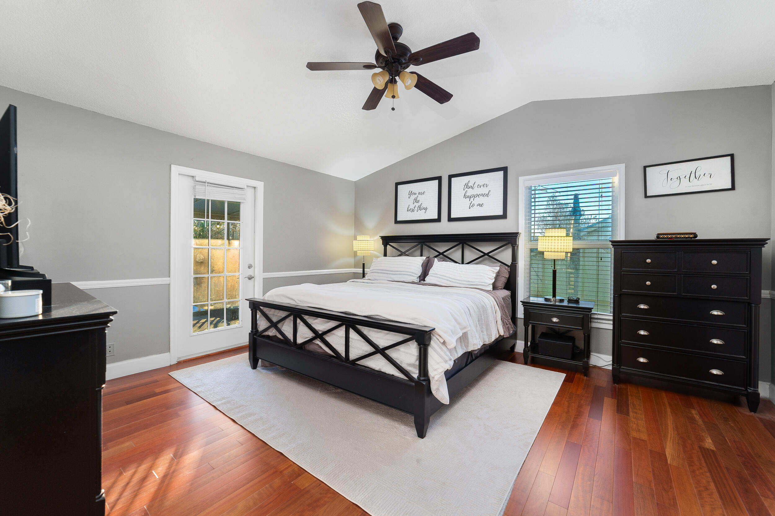 1045 Raintree Lane Wellington, FL 33414 - Photo 21 of 43 a bedroom with a bed and a dresser with the wooden floor