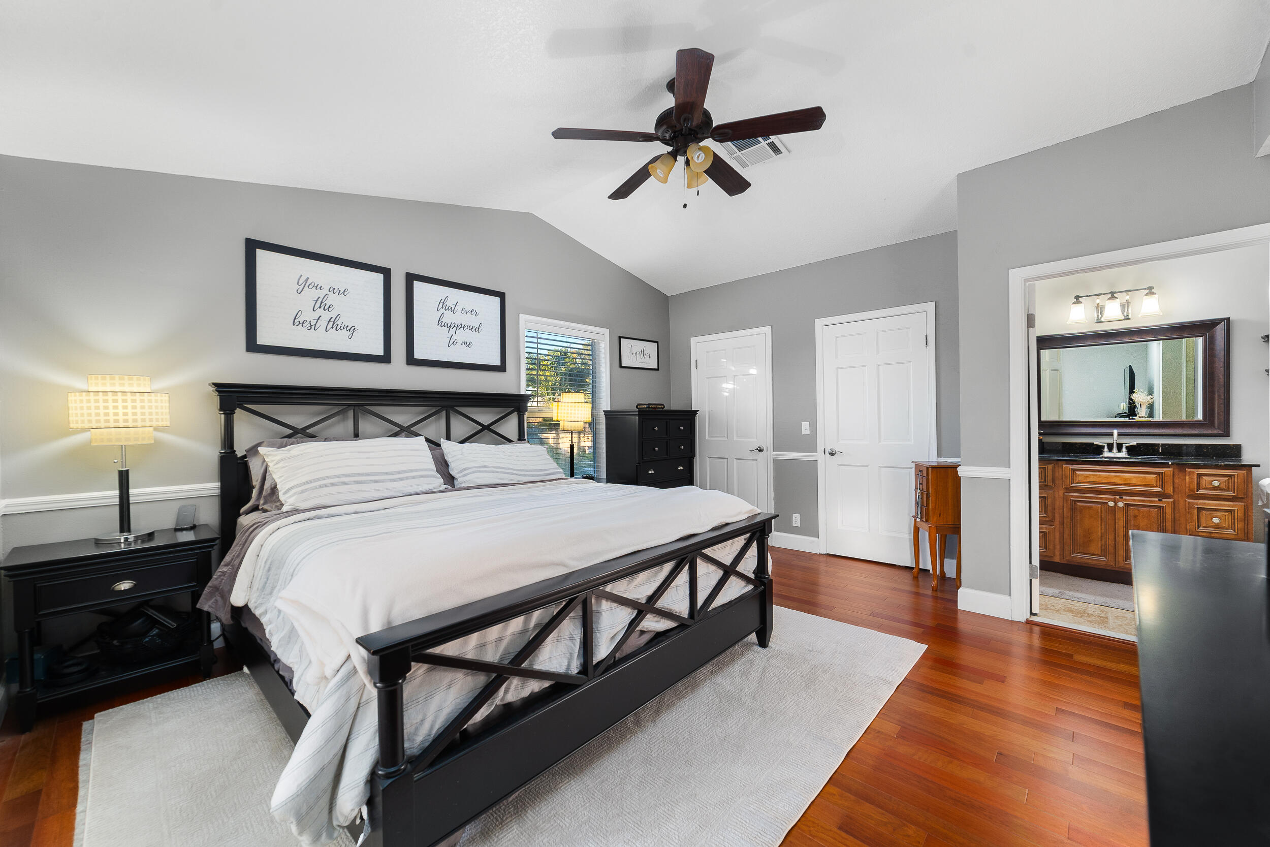 1045 Raintree Lane Wellington, FL 33414 - Photo 22 of 43 a bedroom with a bed and a chandelier