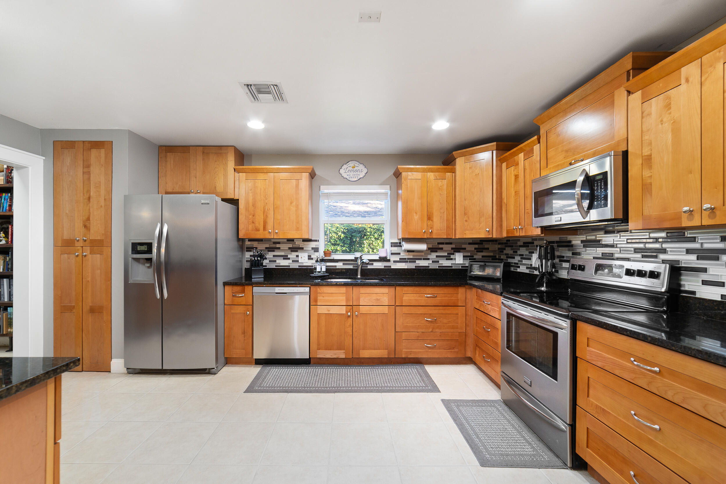 1045 Raintree Lane Wellington, FL 33414 - Photo 7 of 43 a kitchen with stainless steel appliances granite countertop a refrigerator a stove a sink a microwave and island