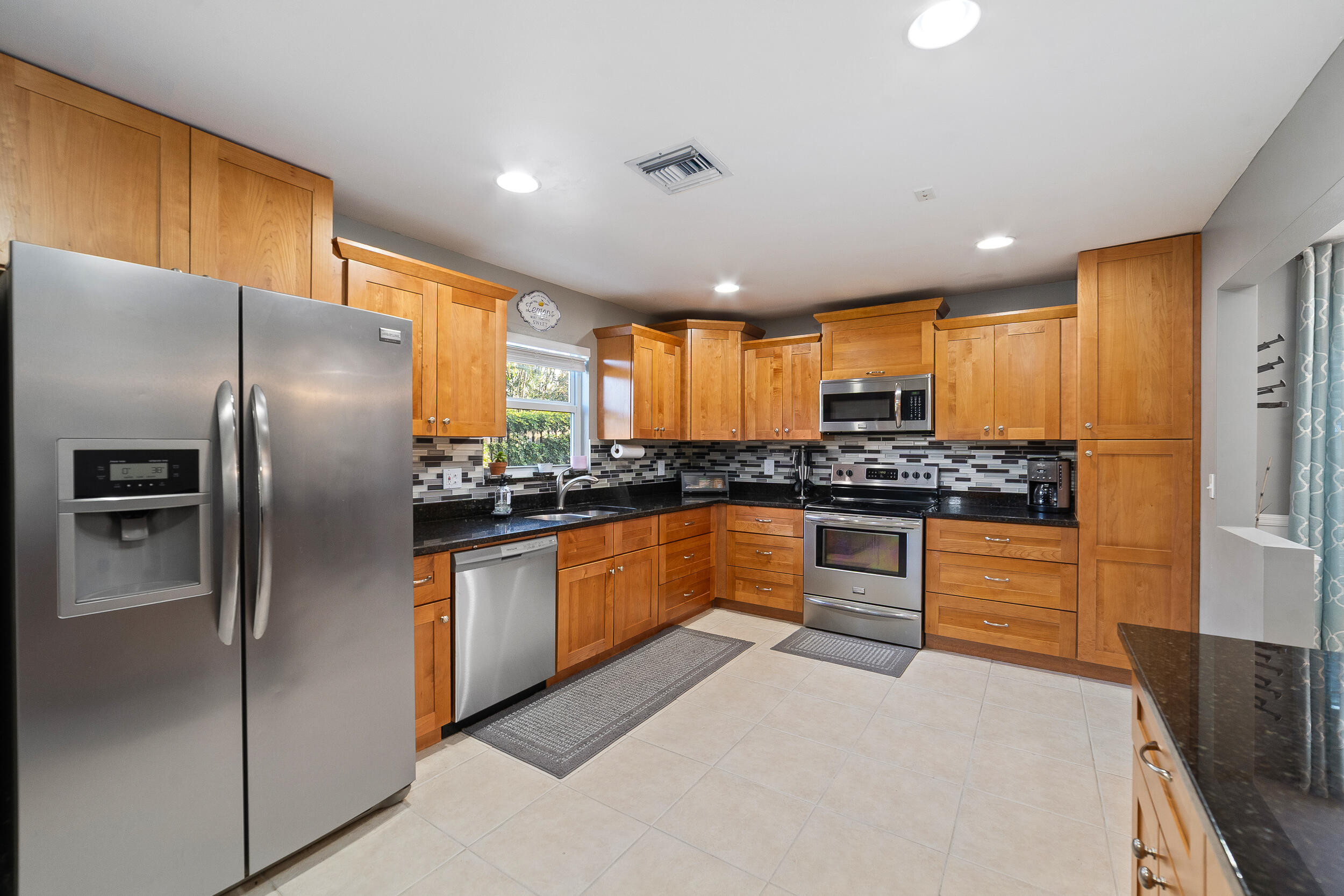 1045 Raintree Lane Wellington, FL 33414 - Photo 8 of 43 a kitchen with stainless steel appliances granite countertop a refrigerator a stove and a sink