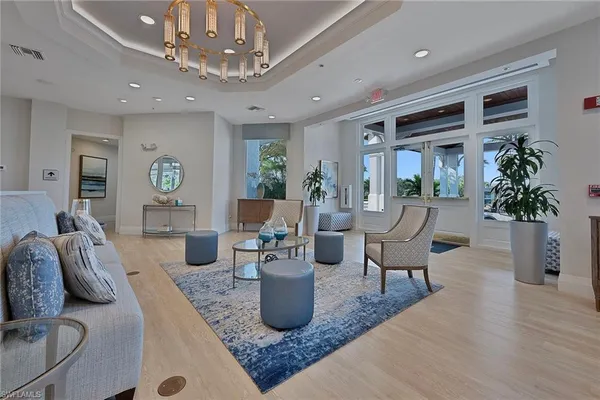 a living room with furniture a chandelier and a dining room
