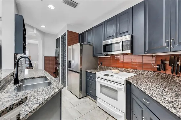 a kitchen with stainless steel appliances granite countertop a stove and a sink