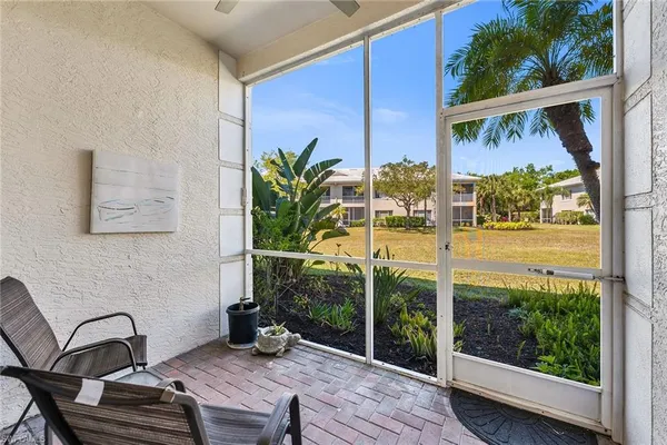a view of a balcony with table and chairs with wooden floor and fence