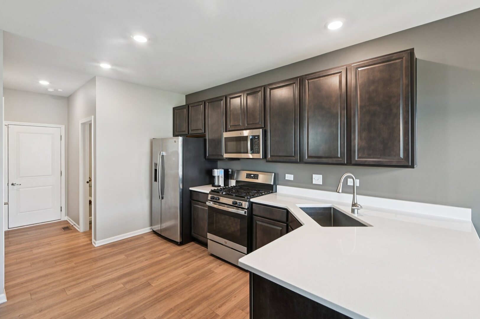 24734 South Dart Road Manhattan, IL 60442 - Photo 6 of 29 a kitchen with stainless steel appliances a sink a stove a refrigerator cabinets and wooden floor