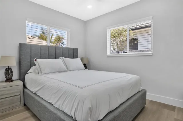 a large bed sitting in a bedroom next to a window