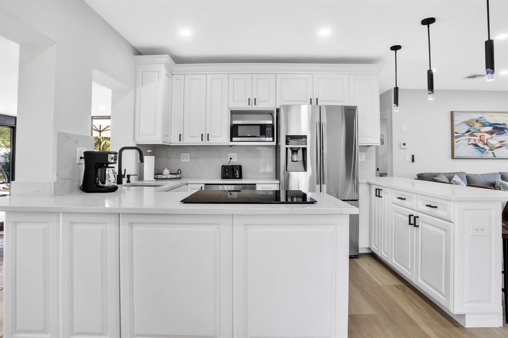 421 Southeast 14th Avenue Pompano Beach, FL 33060 - Photo 15 of 31 a kitchen with stainless steel appliances granite countertop a sink a stove a refrigerator a center island and cabinets