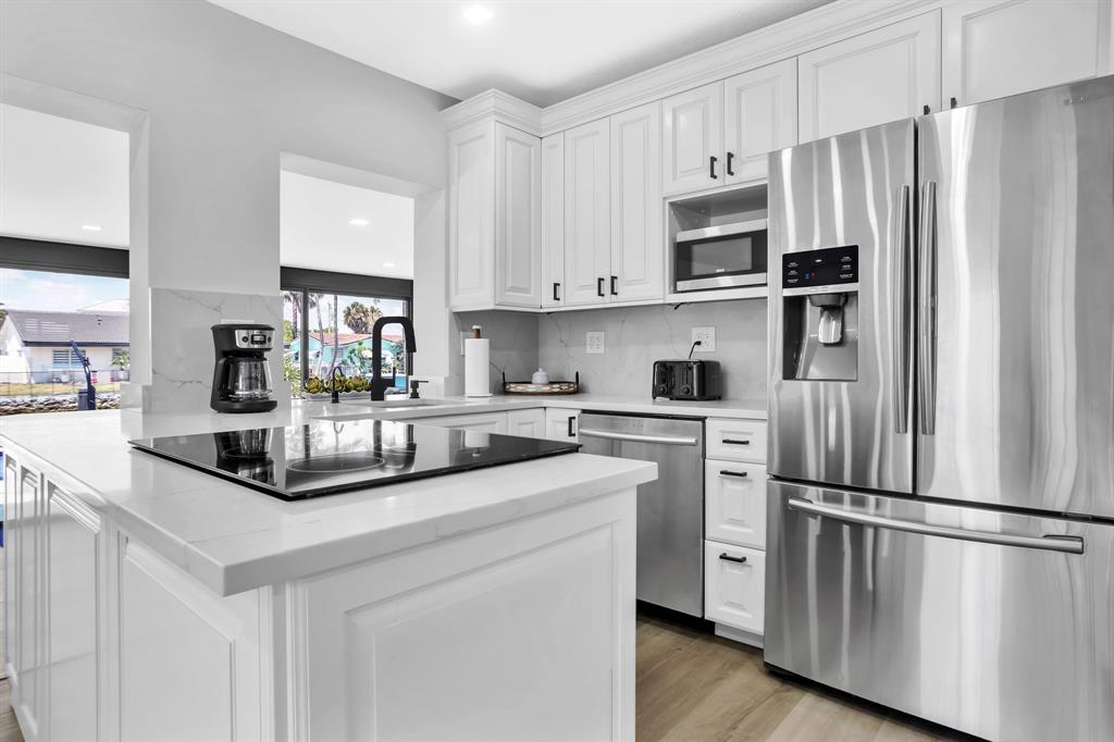 421 Southeast 14th Avenue Pompano Beach, FL 33060 - Photo 17 of 31 a kitchen with stainless steel appliances granite countertop a refrigerator and a stove top oven