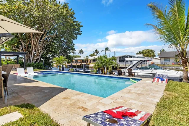 a view of a swimming pool with lounge chairs in patio