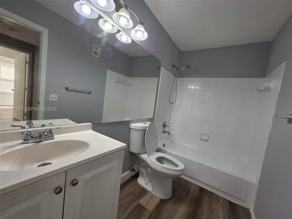 a bathroom with a sink a toilet a mirror and shower