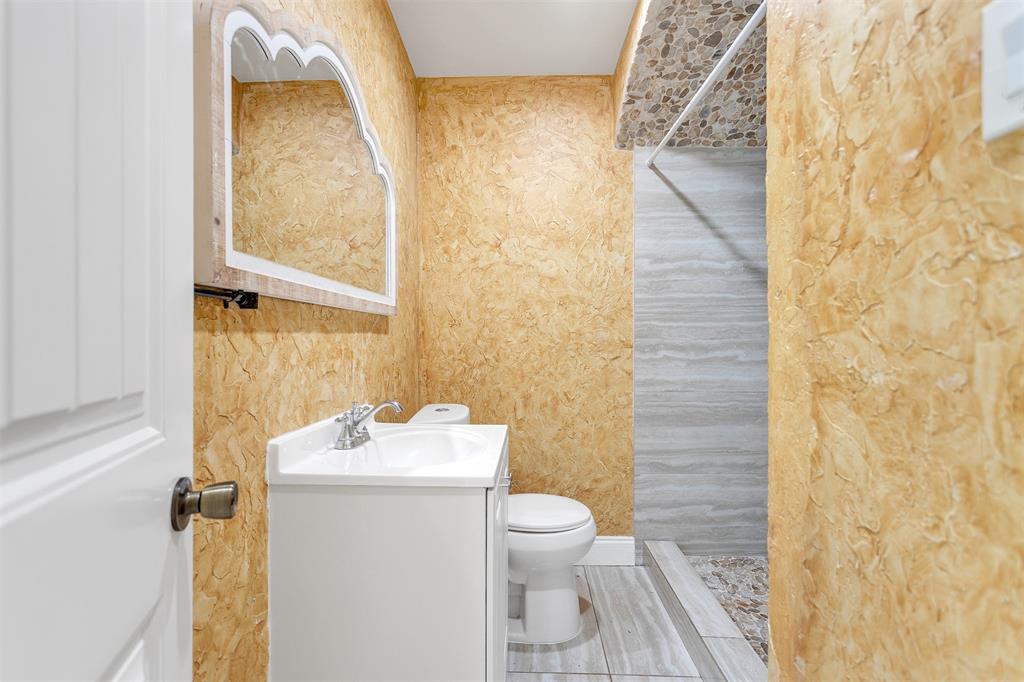 8115 Goldfield Drive Dallas, TX 75217 - Photo 9 of 16 a bathroom with a sink a toilet and a mirror