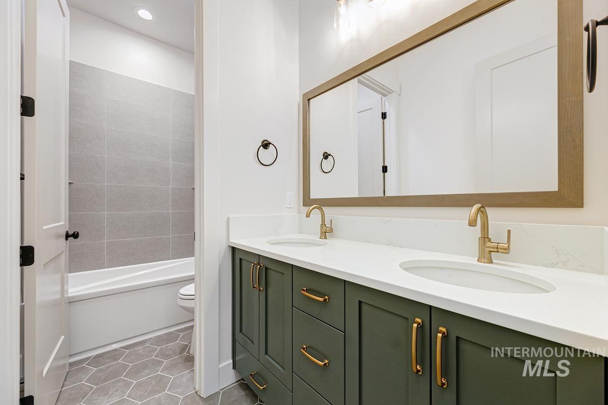 13265 North Spring Creek Way Boise, ID 83714 - Photo 18 of 35 Bathroom featuring double vanity, light tile patterned floors, and bathing tub / shower combination