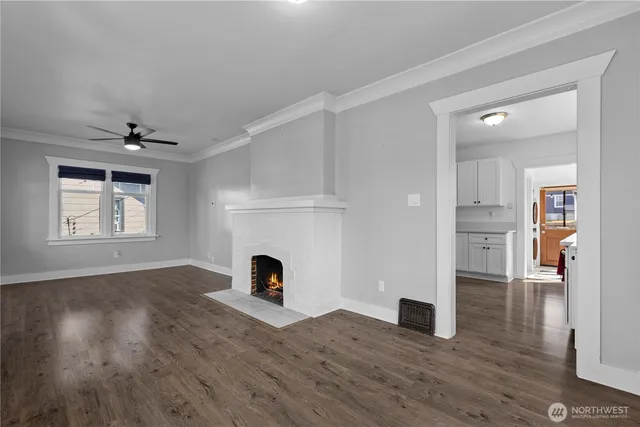a view of empty room with wooden floor and fireplace