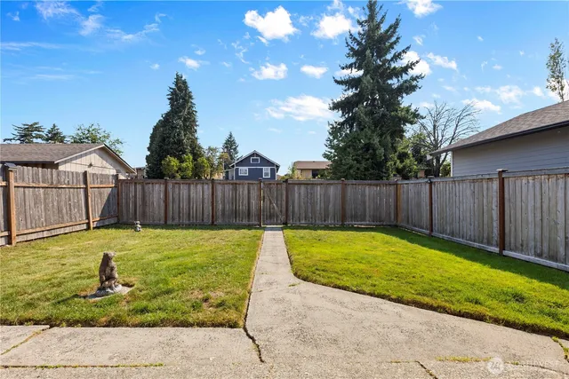a view of back yard with wooden fence
