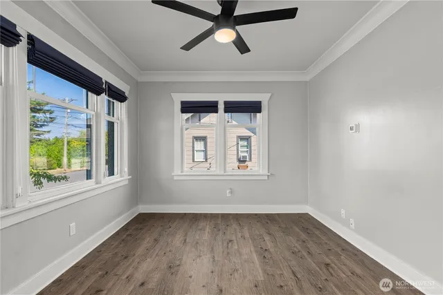 a view of empty room with wooden floor and fan