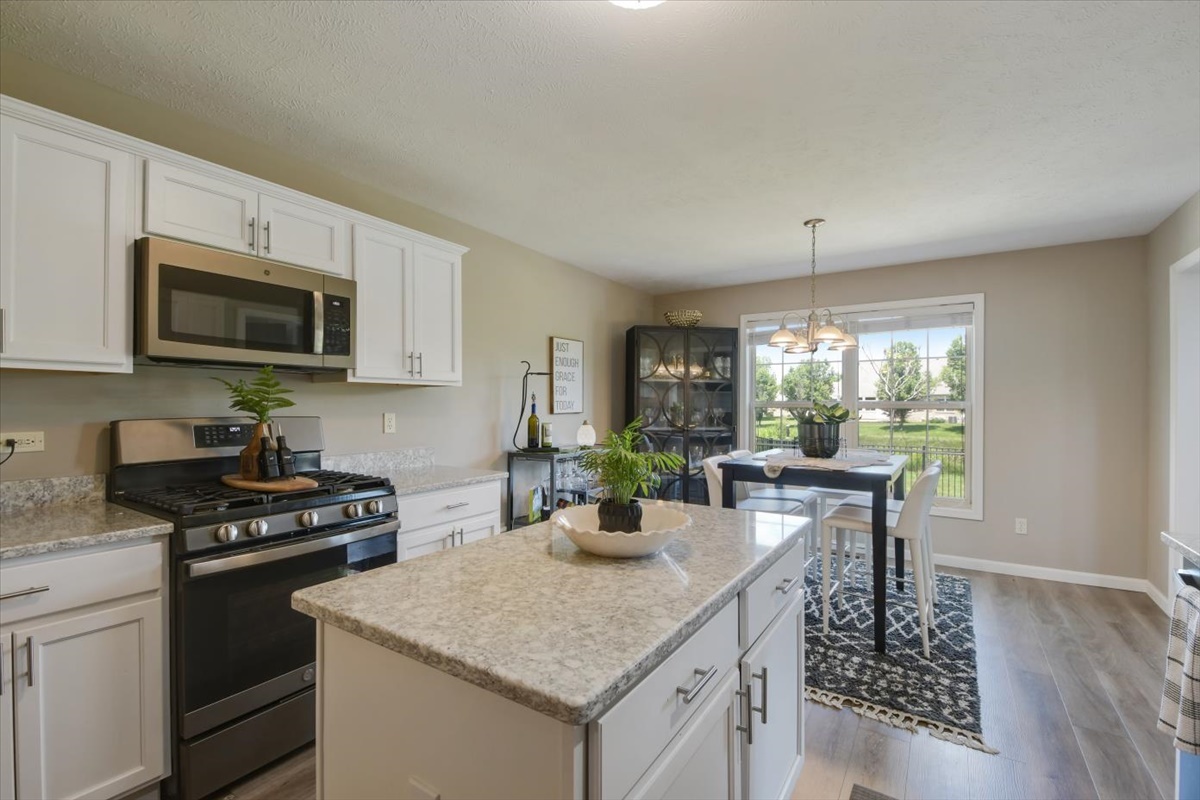 4622 Copper Ridge Road, Unit 4622 Champaign, IL 61822 - Photo 7 of 25 a kitchen with stainless steel appliances kitchen island granite countertop a stove a sink and a microwave