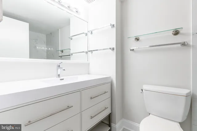 a bathroom with a sin toilet sink and mirror